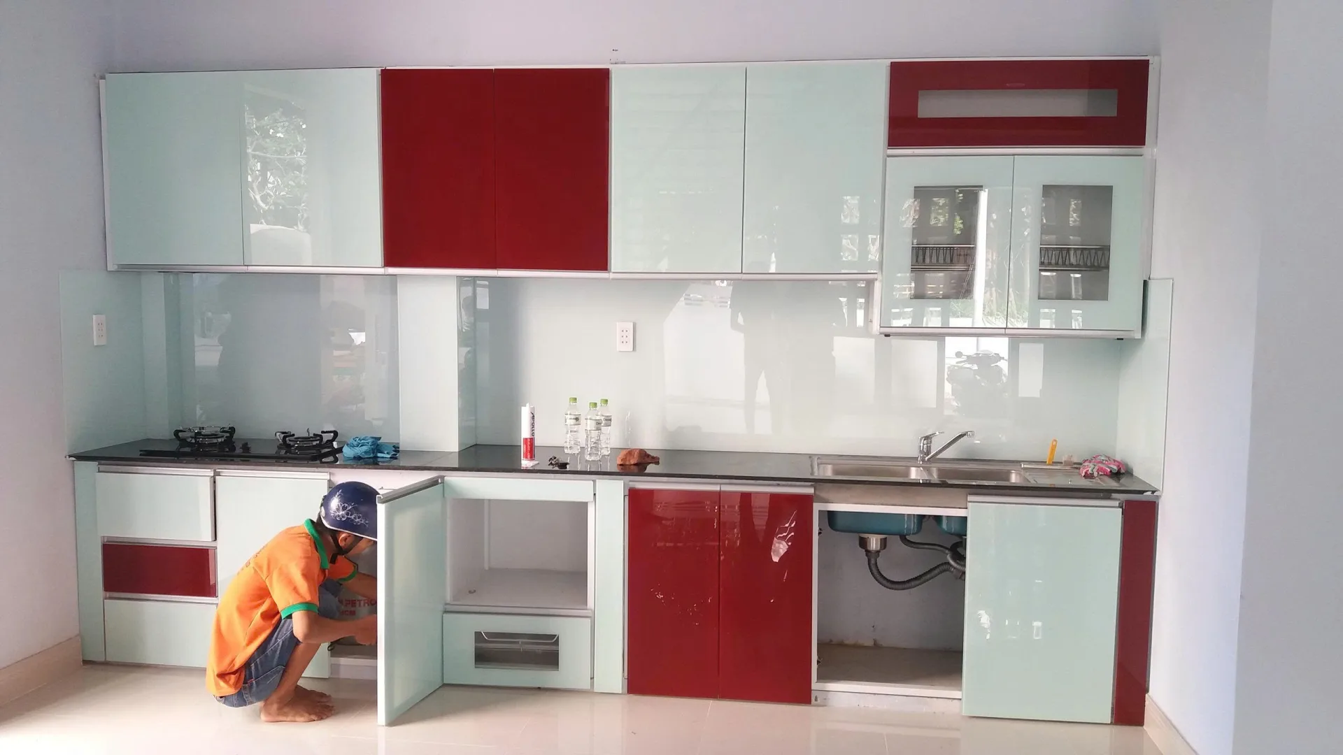 Thi công tủ bếp nhôm kính đỏ trắng tại TP.HCM Tủ bếp nhôm kính phối đỏ trắng đang hoàn thiện tại TP.HCM