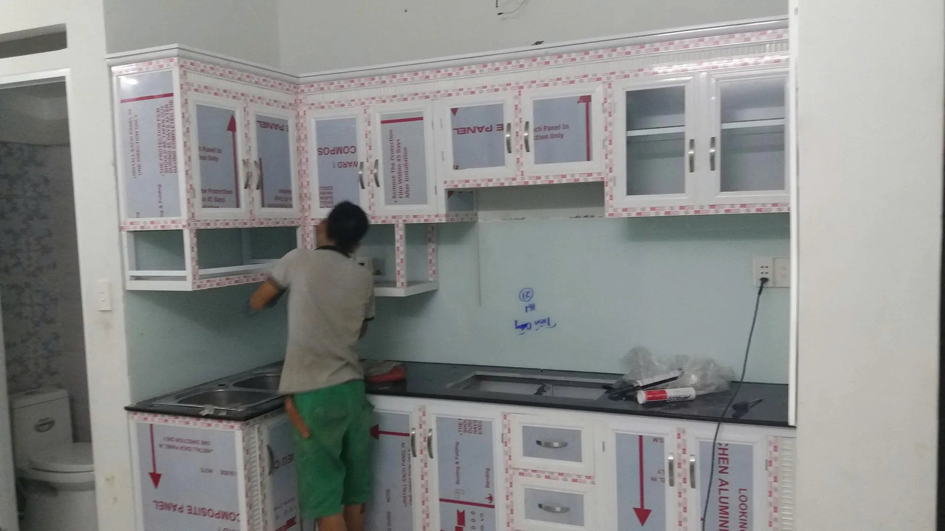 Tủ bếp nhôm kính trắng đang lắp đặt tại TP.HCM Thi công tủ bếp nhôm kính màu trắng tại TP.HCM